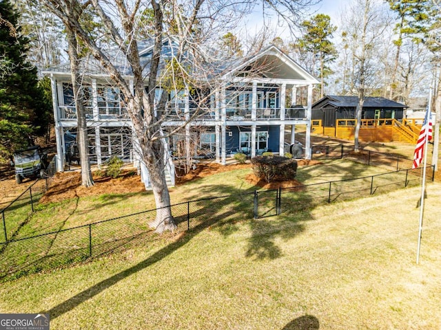 rear view of house featuring a yard and a fenced backyard