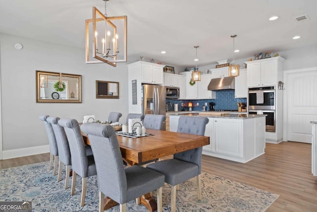 dining room featuring a chandelier, light wood-style flooring, visible vents, and recessed lighting