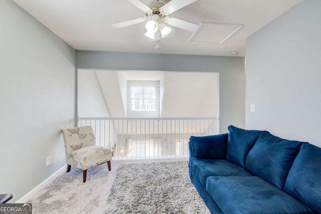 living area with a textured ceiling, carpet, and baseboards