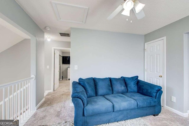 living area featuring attic access, light colored carpet, visible vents, and baseboards