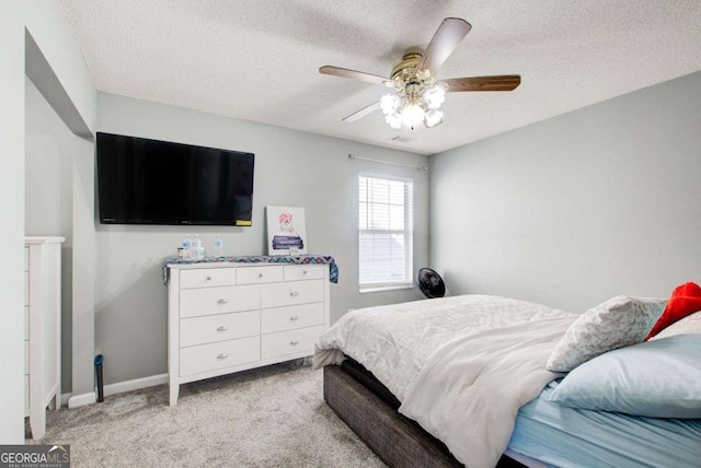 bedroom with a textured ceiling, baseboards, a ceiling fan, and light colored carpet