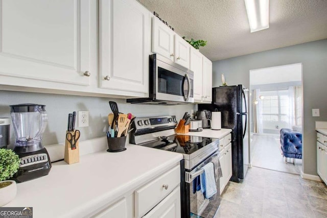 kitchen featuring white cabinets, a textured ceiling, stainless steel appliances, and light countertops