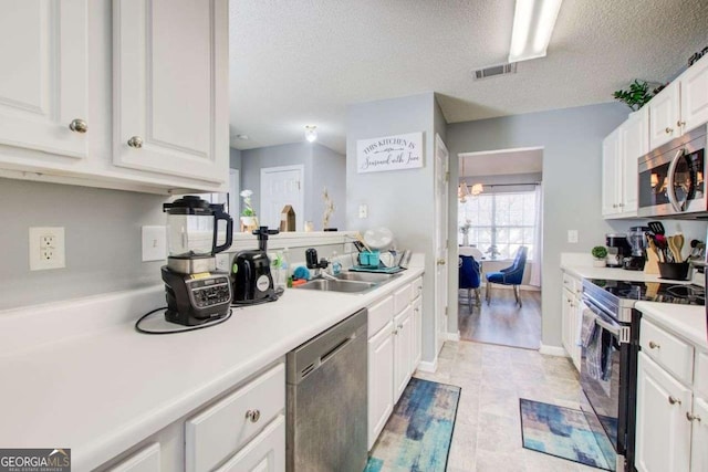 kitchen with visible vents, appliances with stainless steel finishes, white cabinets, and light countertops