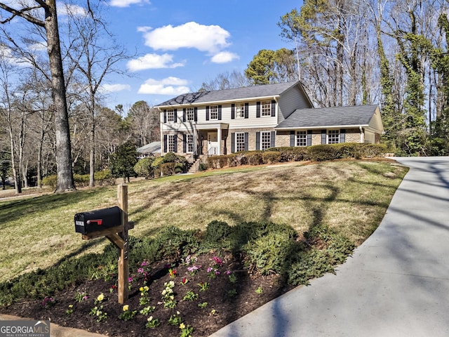 view of front facade featuring a front yard and brick siding