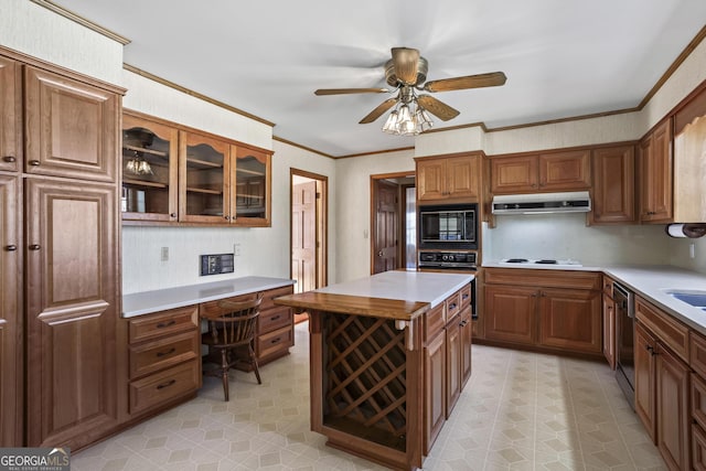 kitchen with light countertops, black appliances, built in study area, and under cabinet range hood