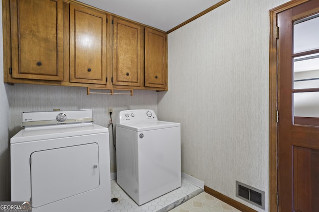 laundry room featuring cabinet space, visible vents, wallpapered walls, and washing machine and clothes dryer