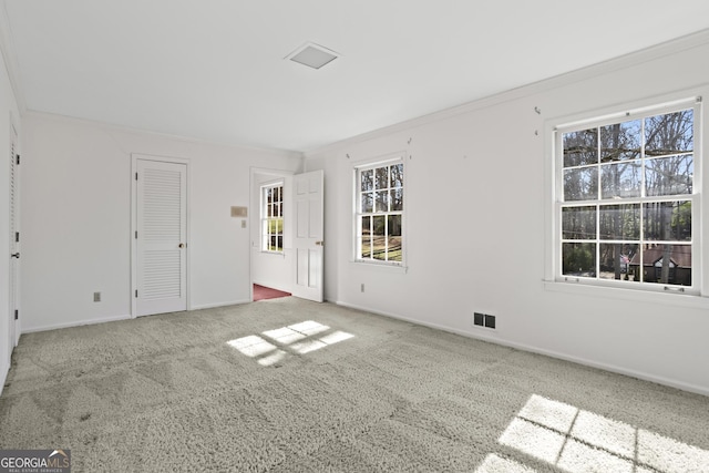 interior space featuring ornamental molding, carpet, visible vents, and baseboards