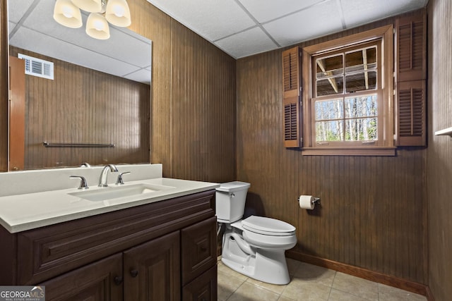 bathroom with visible vents, a drop ceiling, toilet, tile patterned floors, and vanity