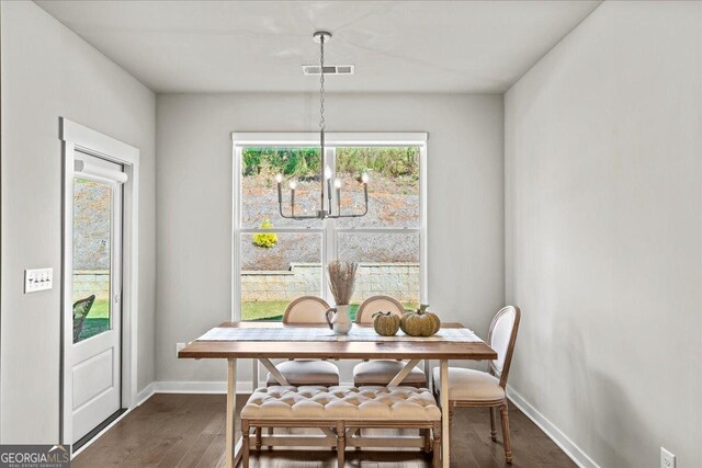 dining area featuring a chandelier, baseboards, dark wood finished floors, and visible vents