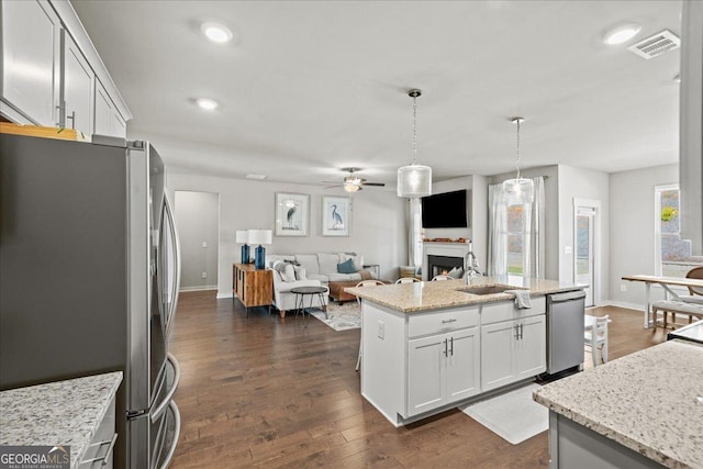 kitchen featuring open floor plan, visible vents, ceiling fan, stainless steel appliances, and a sink