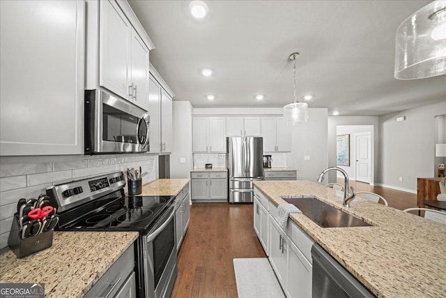 kitchen with dark wood finished floors, recessed lighting, a sink, stainless steel appliances, and backsplash