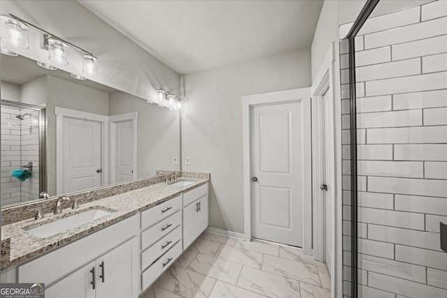 full bath featuring a sink, double vanity, marble finish floor, and a stall shower