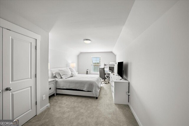 bedroom featuring light carpet, baseboards, and vaulted ceiling