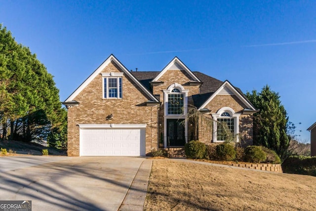 traditional-style house with concrete driveway, brick siding, and an attached garage