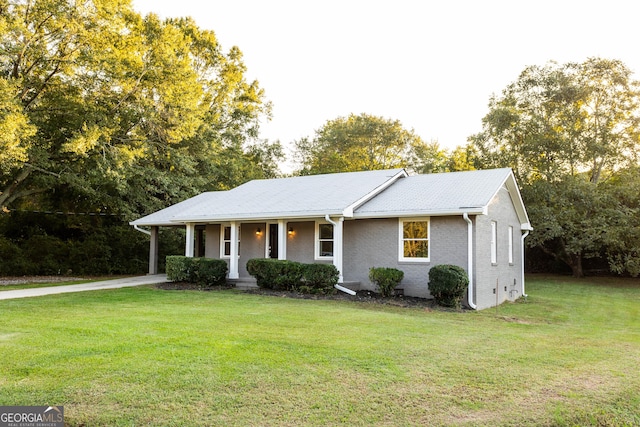 single story home with a porch, a front yard, and brick siding