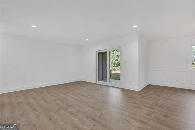 unfurnished room with baseboards, light wood finished floors, and recessed lighting