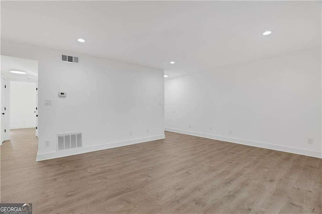 unfurnished room featuring light wood-style flooring, visible vents, and baseboards