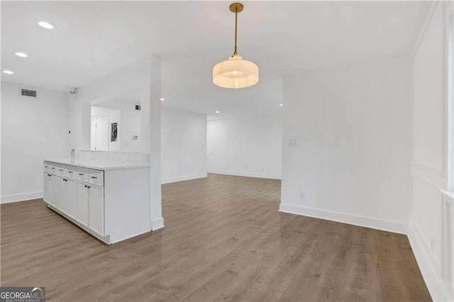 kitchen featuring light wood-style flooring, visible vents, white cabinetry, open floor plan, and light countertops