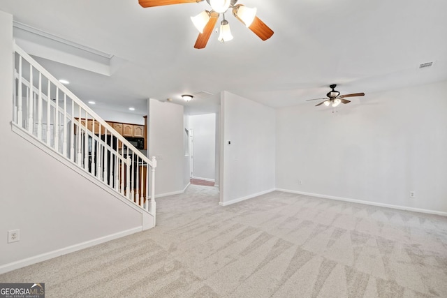 spare room with visible vents, light carpet, baseboards, and stairs