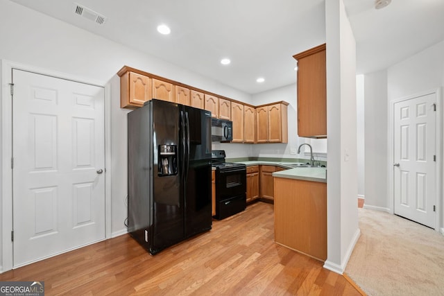 kitchen featuring recessed lighting, a sink, visible vents, light countertops, and black appliances