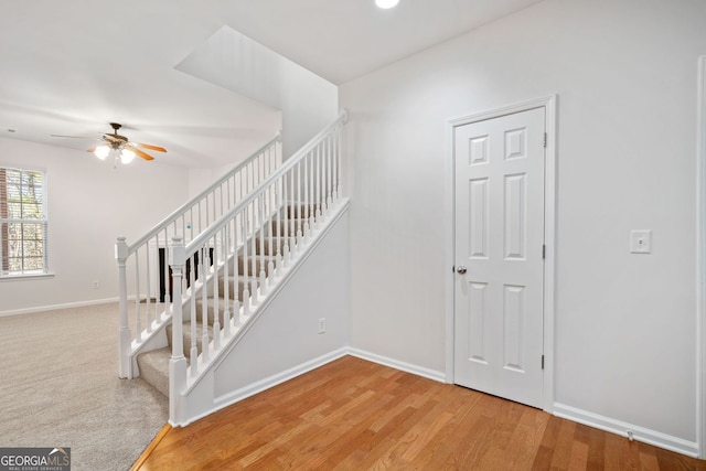 stairs featuring ceiling fan, baseboards, and wood finished floors