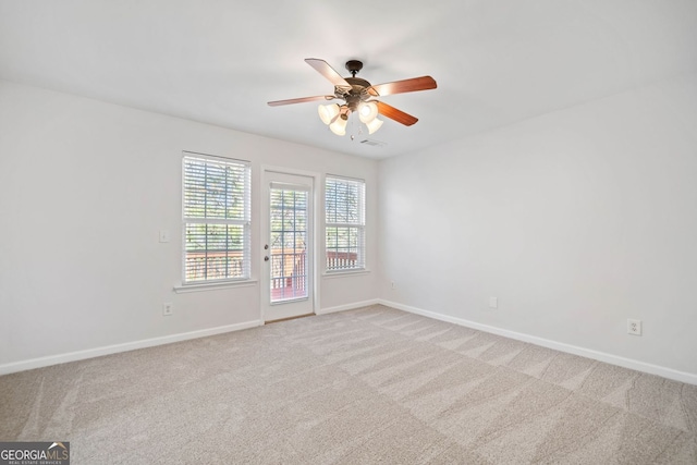 spare room with visible vents, baseboards, and light colored carpet