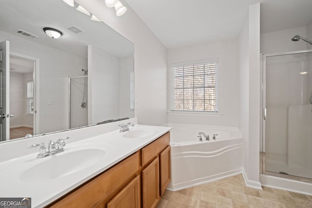 bathroom with visible vents, a sink, and a garden tub