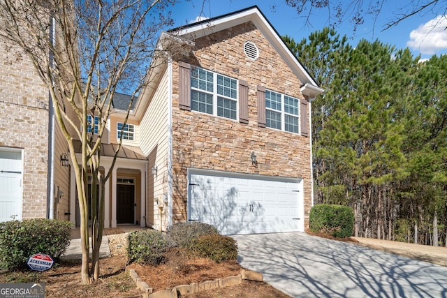 traditional-style home featuring a garage, stone siding, and driveway