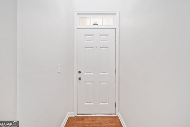 doorway to outside with light wood-style flooring and baseboards