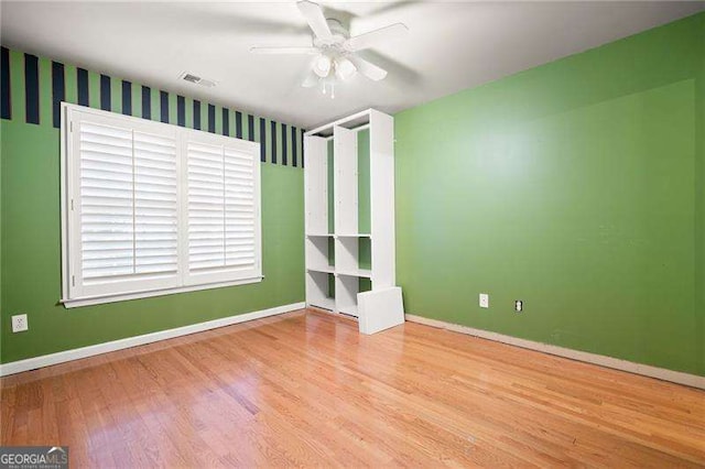 interior space with visible vents, ceiling fan, light wood finished floors, and baseboards