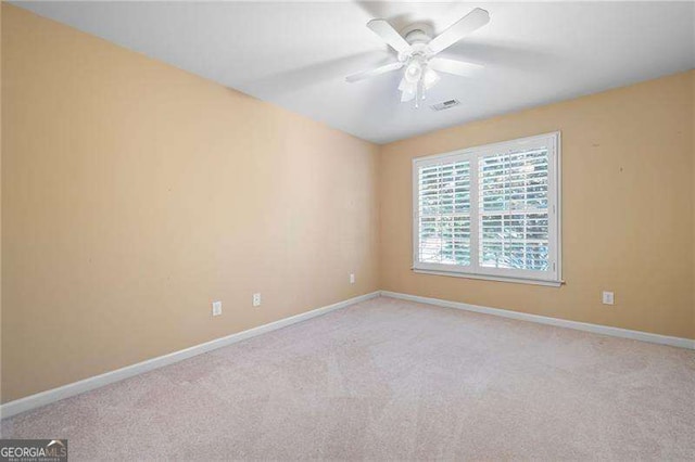 empty room featuring light colored carpet, visible vents, and baseboards