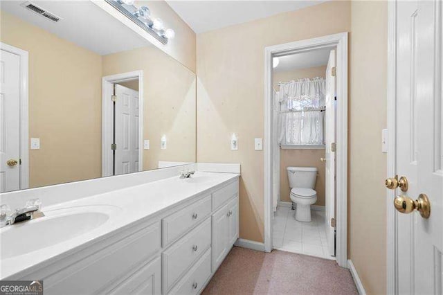 bathroom featuring toilet, a sink, visible vents, baseboards, and double vanity