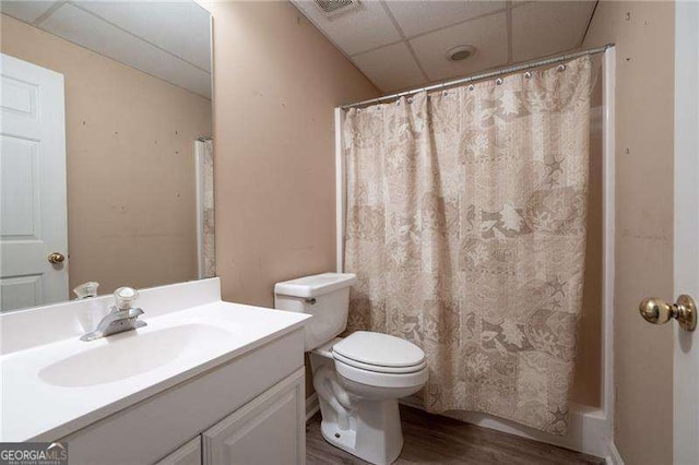 bathroom featuring a drop ceiling, toilet, wood finished floors, vanity, and a shower with curtain