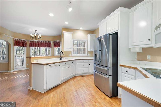 kitchen featuring white appliances, light countertops, and white cabinetry