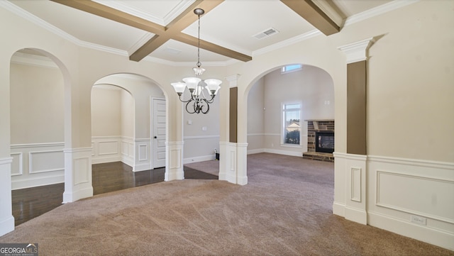 unfurnished dining area with dark colored carpet, visible vents, a stone fireplace, coffered ceiling, and beamed ceiling