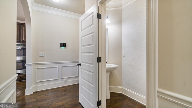 bathroom with a wainscoted wall, crown molding, a decorative wall, and hardwood / wood-style floors