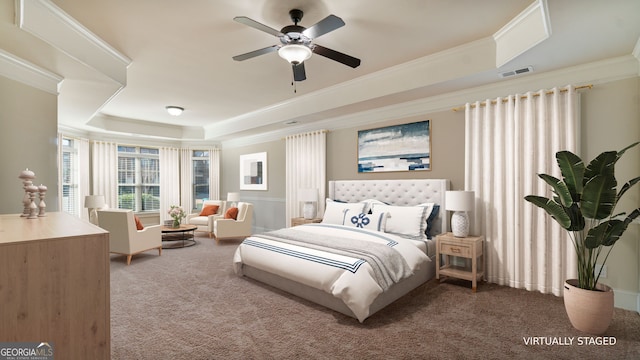 carpeted bedroom with ornamental molding, a raised ceiling, visible vents, and ceiling fan