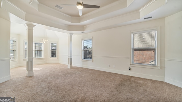 unfurnished room with decorative columns, visible vents, a raised ceiling, ornamental molding, and carpet floors