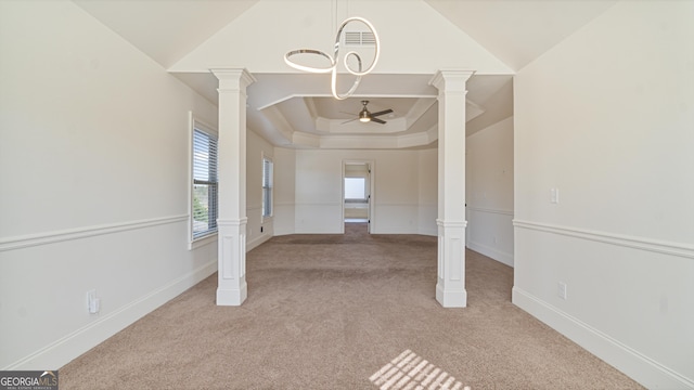 interior space featuring a ceiling fan, baseboards, carpet flooring, and ornate columns