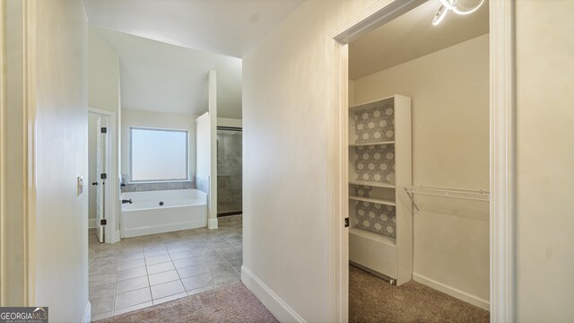 bathroom featuring tile patterned flooring and a garden tub