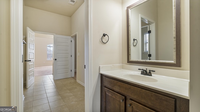 bathroom featuring visible vents, vanity, baseboards, and tile patterned floors