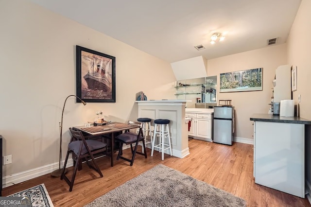 397 4th St NE, Atlanta, GA 30308 - kitchen featuring freestanding refrigerator, light wood-type flooring, white cabinets, and dark countertops