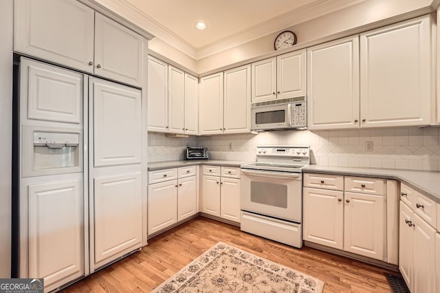 397 4th St NE, Atlanta, GA 30308 - kitchen featuring white appliances, ornamental molding, light wood-type flooring, light countertops, and decorative backsplash