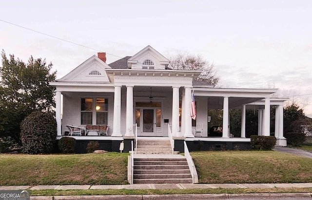 greek revival inspired property with a porch and a front yard