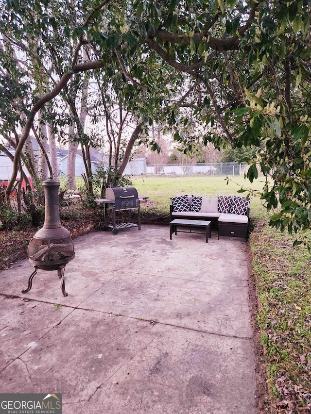 view of community with a yard, an outdoor fire pit, a patio area, and fence