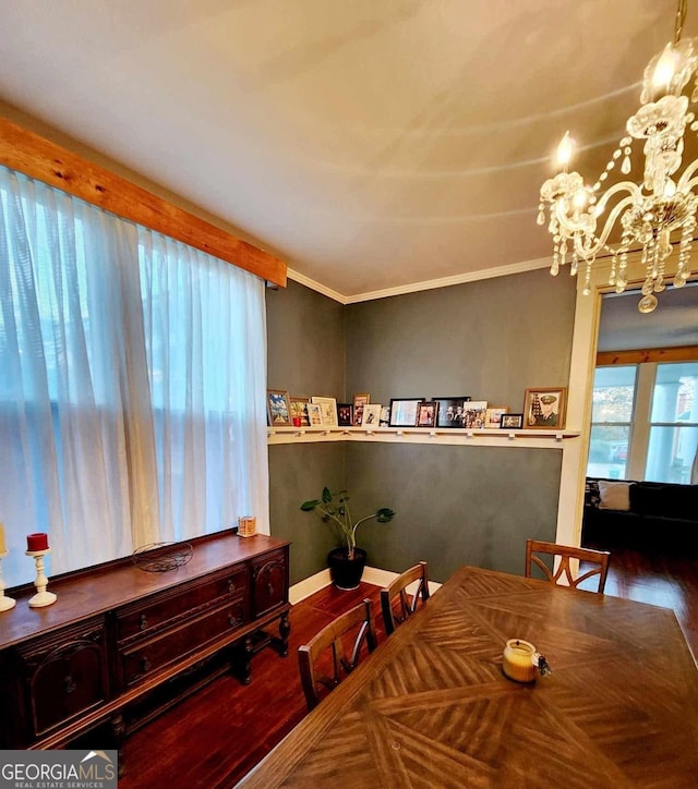 dining room with baseboards, a notable chandelier, ornamental molding, and wood finished floors