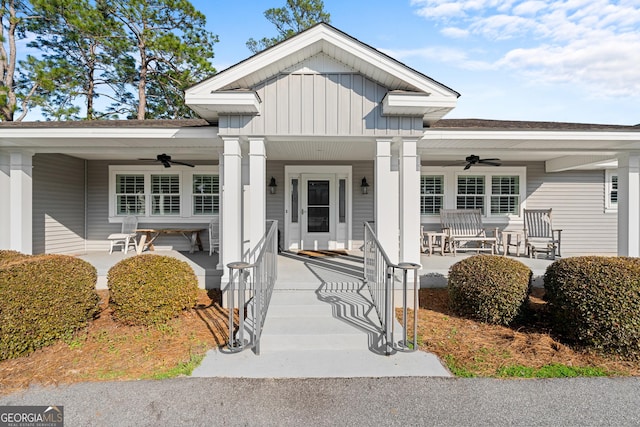 view of exterior entry with board and batten siding, covered porch, and ceiling fan