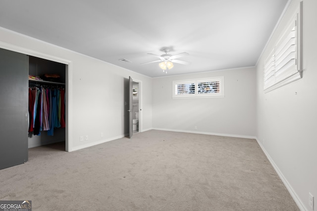 unfurnished bedroom with light carpet, a ceiling fan, baseboards, a closet, and crown molding