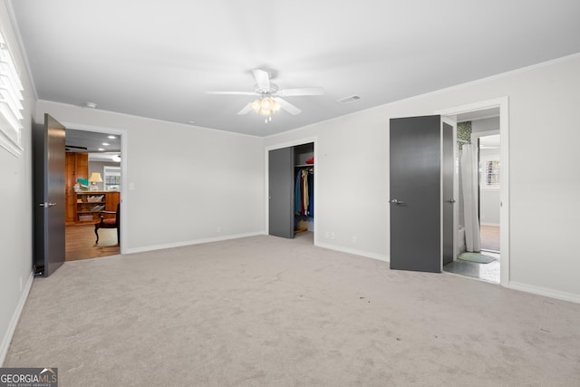 unfurnished bedroom featuring baseboards, visible vents, light colored carpet, ornamental molding, and a closet