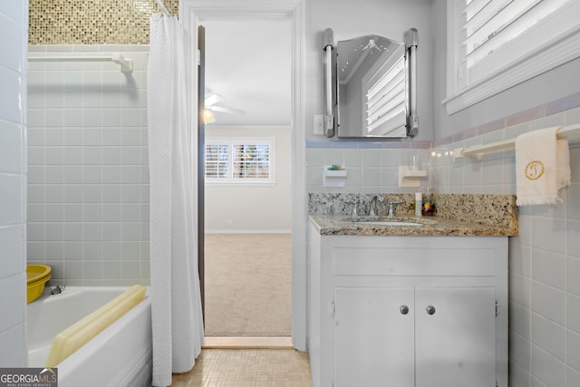 full bath featuring vanity, shower / bath combo with shower curtain, and tile walls